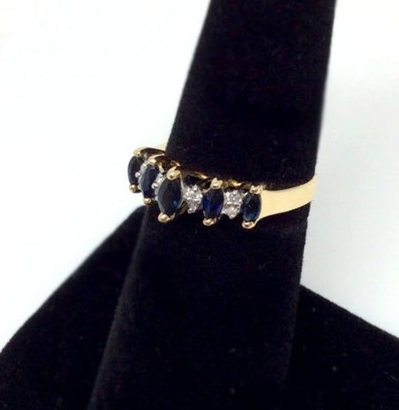 Sale! Was $1300 This ring features glistening marquise-cut sapphires, separated by 8 white diamonds, which are placed by pair to make an illusion of the same - marquise shape. All set in stately cathedral 14k yellow gold band. Sapphire and diamond rings are an ideal gift for birthday and anniversary milestones. Size: 6 and can be resized Weight: 2.6 Grams Width: 6mm Anniversary Milestones, Sapphire Diamond Ring, Gift For Birthday, Marquise Cut, Sapphire Diamond, Gold Band, White Diamonds, Gold Bands, Milestones