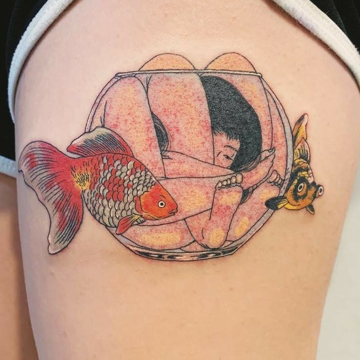 a woman's thigh with a fish and goldfish tattoo on it