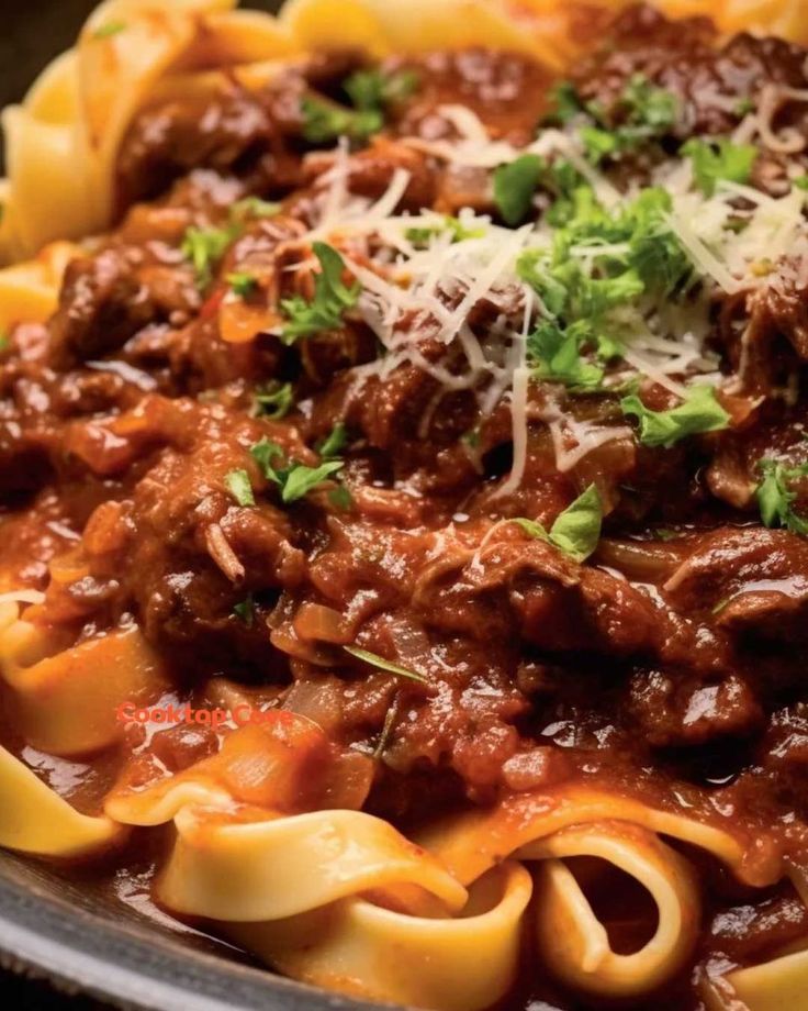 pasta with meat sauce and parmesan cheese on top