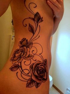 a woman's lower back tattoo with roses on it