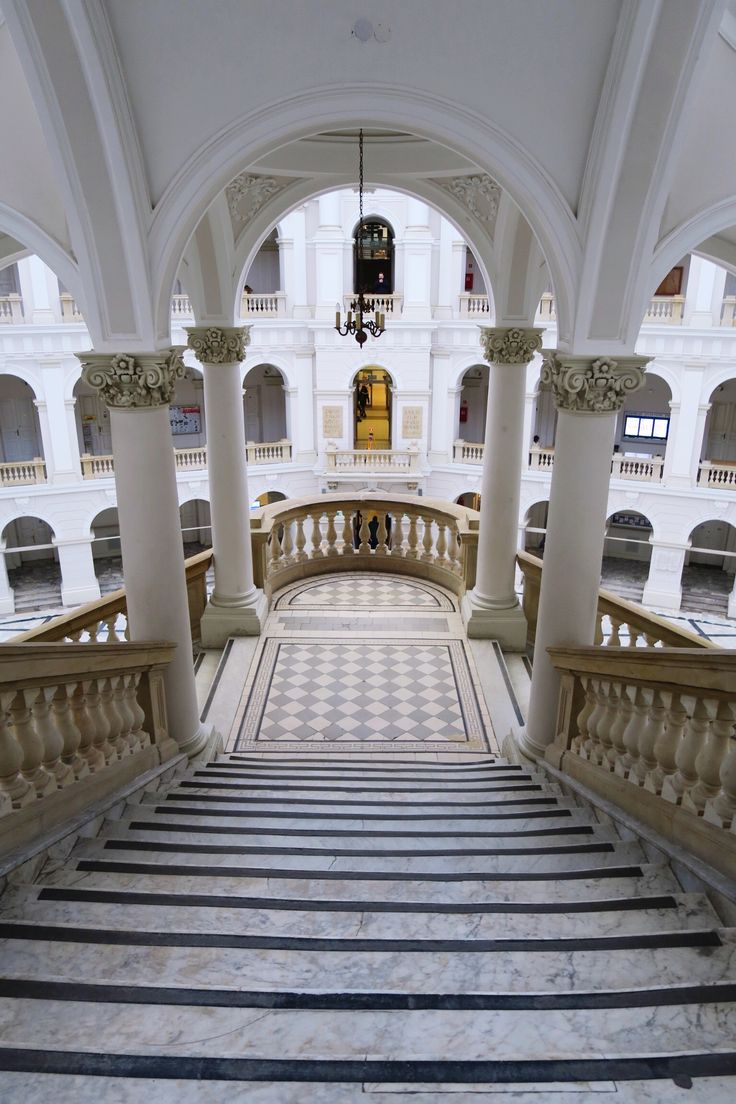 the stairs are lined with marble columns and decorative balconies in an ornate building