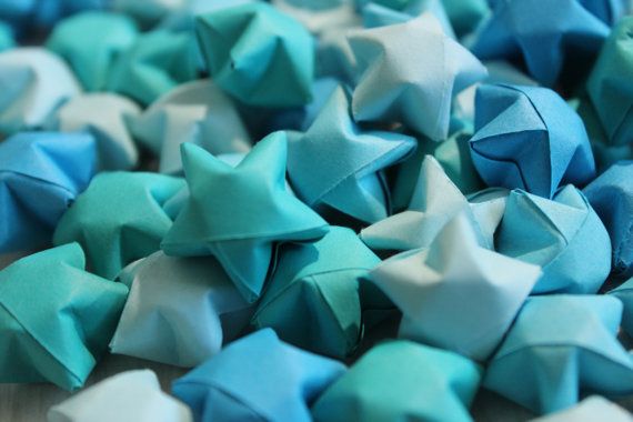 blue and white origami stars are scattered on top of each other in this close up photo