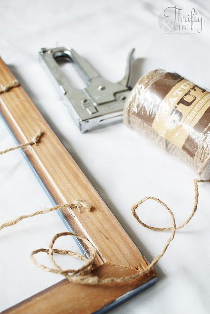 a roll of twine tied to a piece of wood next to a pair of scissors