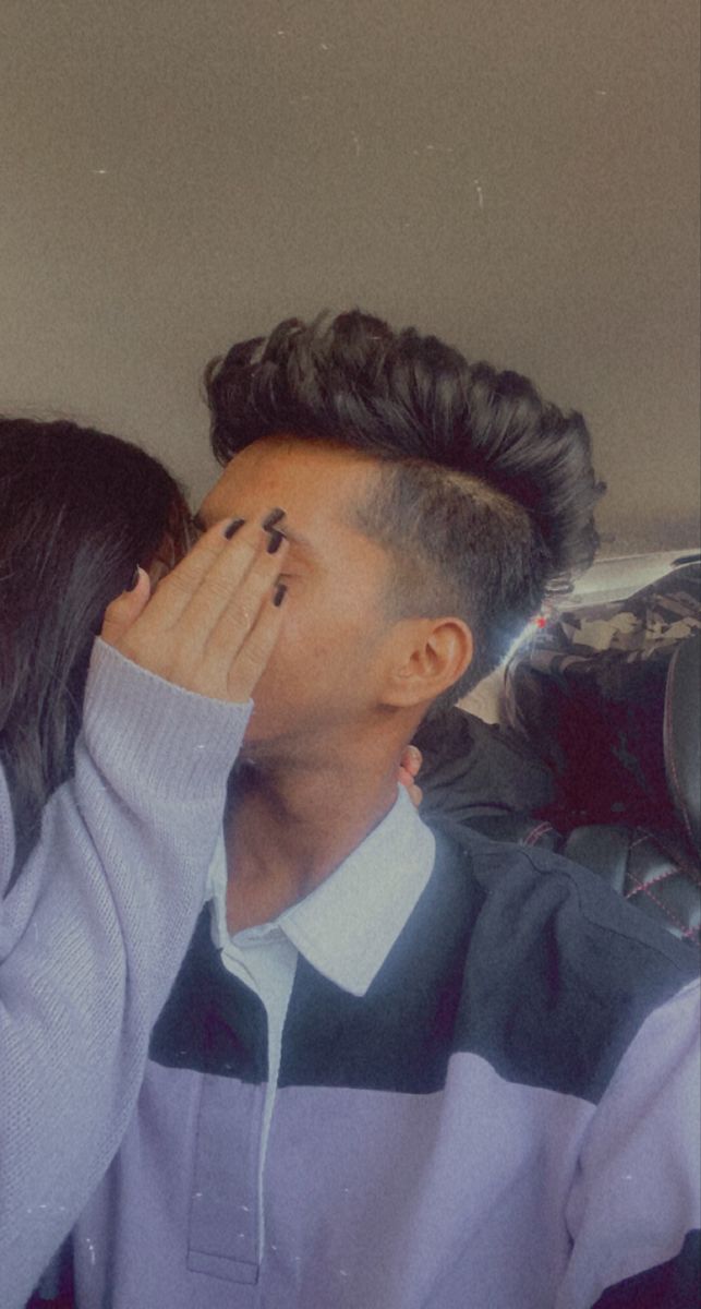 a man covering his eyes while sitting next to a woman