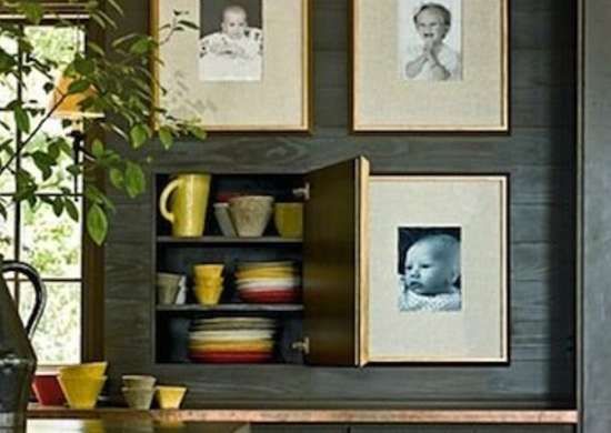 a kitchen with pictures hanging on the wall and dishes stacked in front of each other