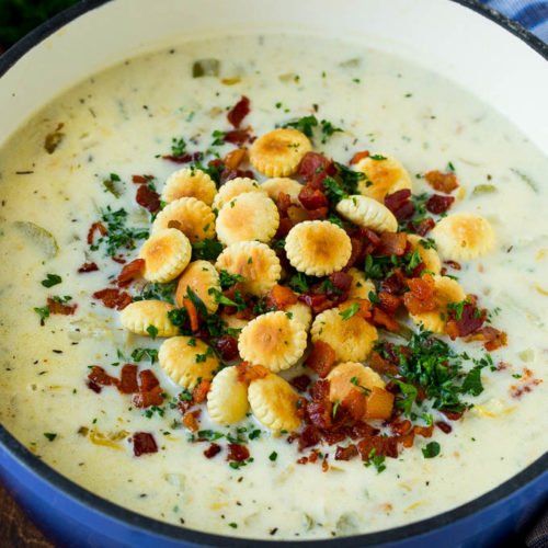 a blue pot filled with soup topped with dumplings and bacon