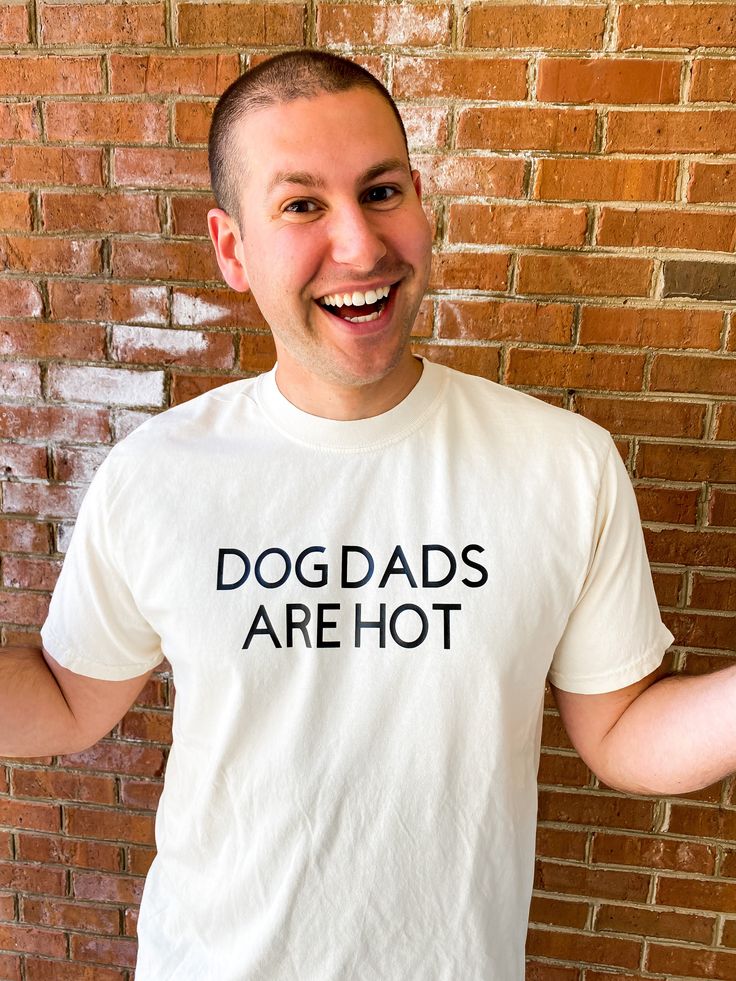 Details Looking for a gift for an awesome dog dad in your life? This funny shirt will let the world know that he is a proud dog dad and that he's good lookin at the same time. This shirt features Dog Dads Are Hot in black vinyl on a cream comfort colors tshirt. Due to lighting and differences in monitors, actual colors may vary slightly from what appears online Materials 80% Cotton 20% Polyester Funny Father's Day Tops With Screen Print, Funny Screen Print Top For Father's Day, Funny Screen Print Tops For Father's Day, Father's Day Funny Text Cotton T-shirt, Father's Day Cotton Slogan T-shirt, Father's Day Cotton T-shirt With Slogan, Father's Day T-shirt With Funny Text In Relaxed Fit, Father's Day Funny Text Cotton Tops, Funny Screen Print T-shirt For Father's Day