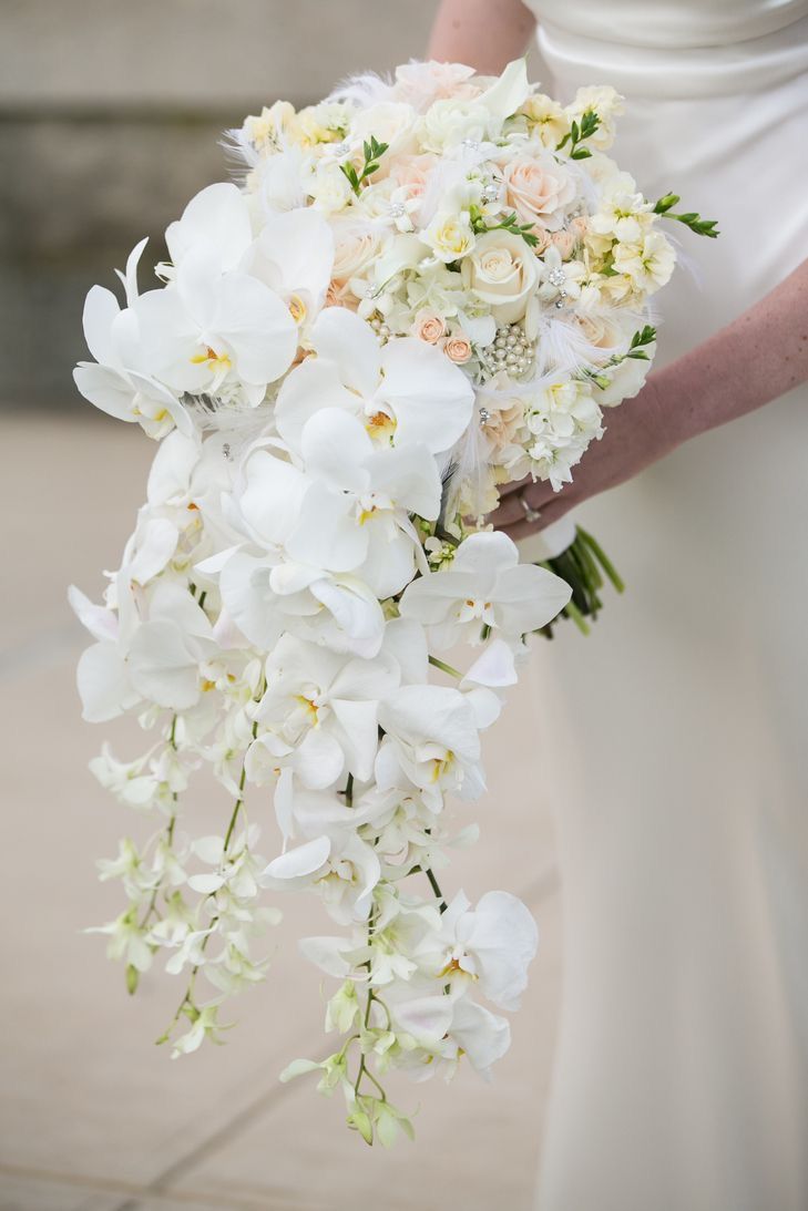 a bride holding a bouquet of white flowers