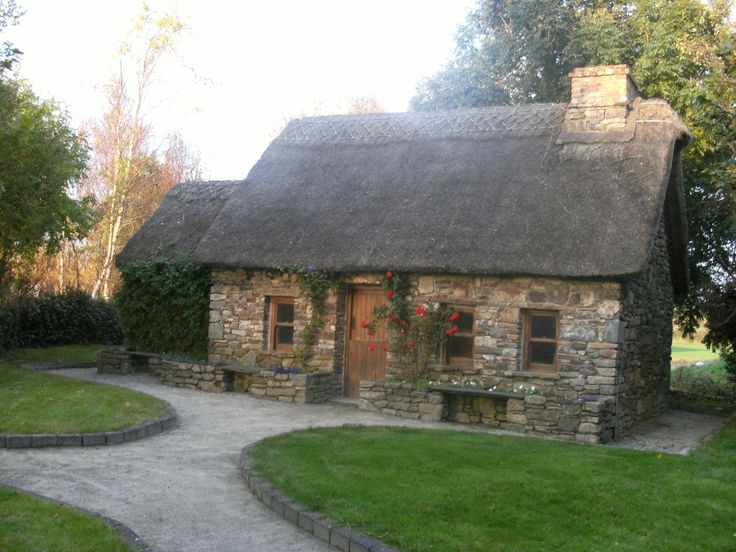 an old stone house with a thatched roof