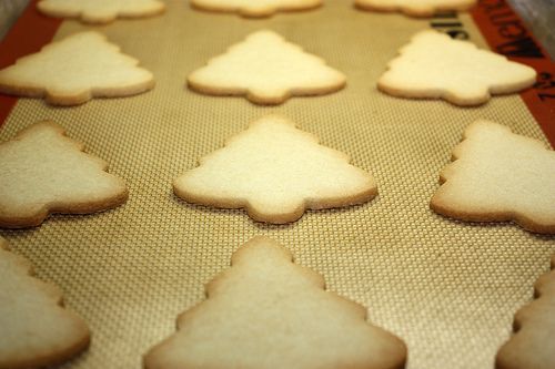 some cookies are sitting on a cookie sheet and ready to be cut into christmas trees