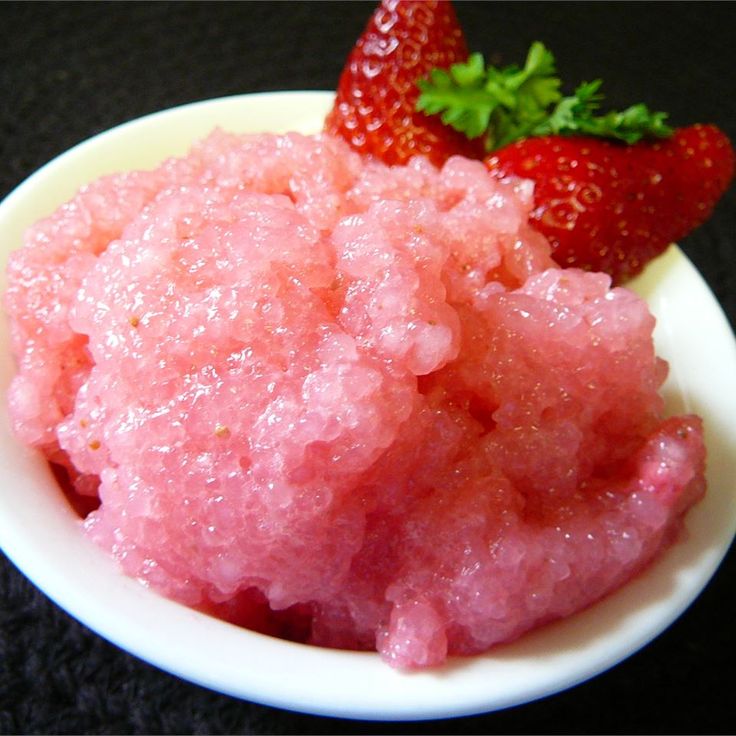 strawberry souffle in a small white bowl on a black surface