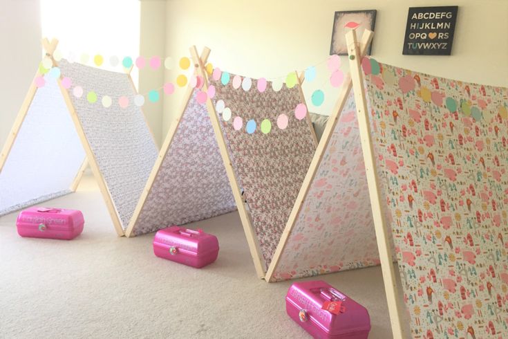 three children's teepees are lined up on the floor next to suitcases