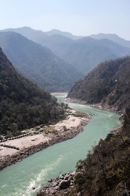 a river flowing through a valley surrounded by mountains