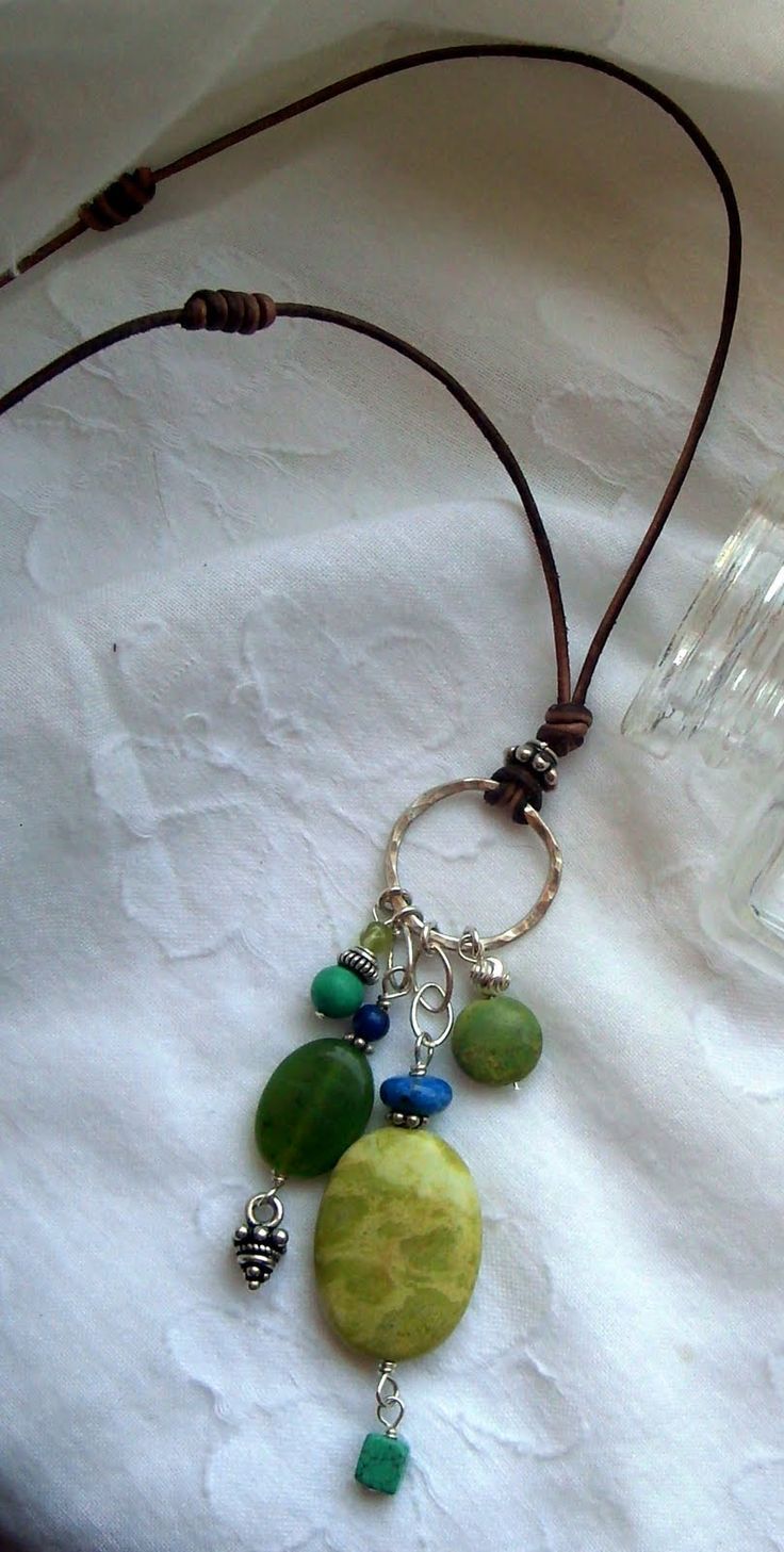 a necklace with beads and charms hanging from it's side on a white surface