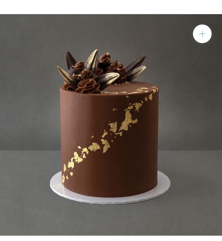 there is a chocolate cake with gold decorations on it