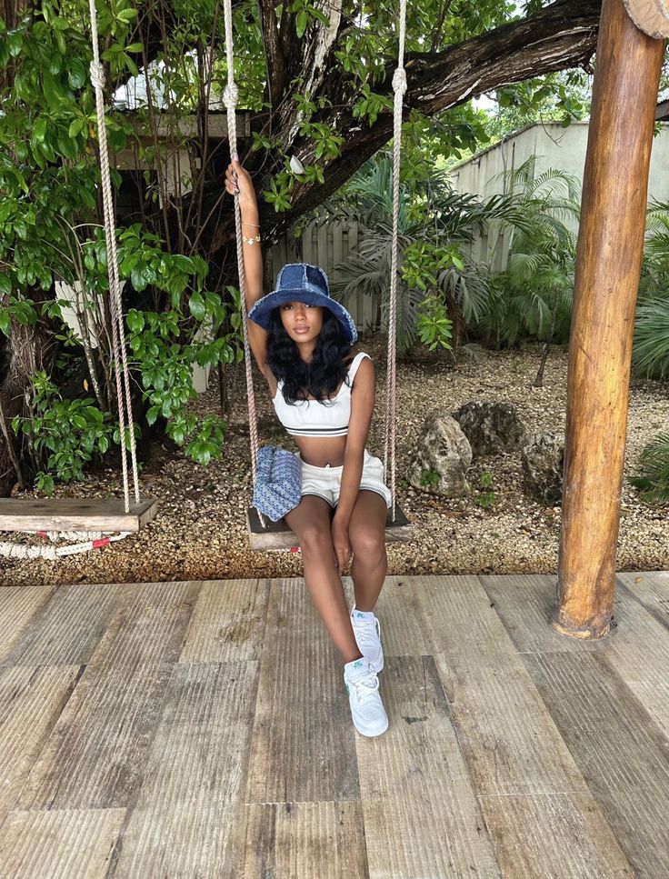 a woman sitting on a swing in the middle of a wooden deck