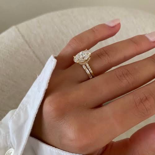 a woman's hand with a diamond ring on her left hand, wearing a white shirt