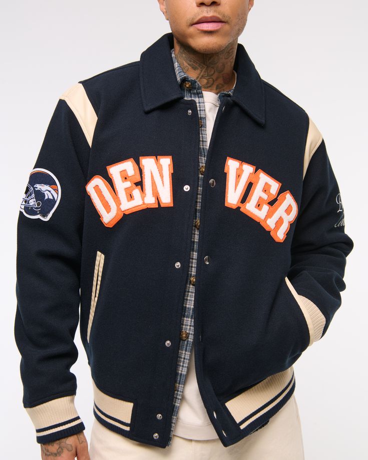 Classic bomber jacket in a soft faux wool fabric and relaxed-fit silhouette, featuring Denver Broncos varsity-inspired embroidered graphic patch details throughout, side pockets, snap-up front and tipping details at elastic cuffs and waistband. Sporty Winter Outerwear For Game Day, Fall Varsity Jacket With Embroidered Patch And Long Sleeves, Fall Varsity Jacket With Embroidered Patch, Long Sleeve Outerwear With Ribbed Cuffs For Game Day, Throwback Long Sleeve Outerwear For Game Day, Winter Outerwear With Letter Patch And Long Sleeve, Wool Outerwear With Embroidered Logo And Long Sleeves, Wool Outerwear With Embroidered Logo, Varsity Long Sleeve Outerwear For Game Day