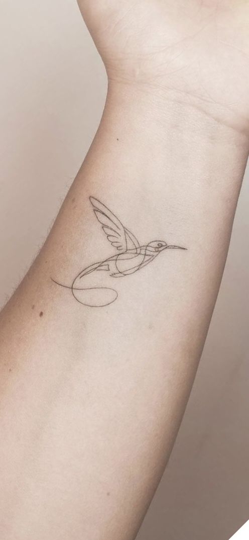 a small hummingbird tattoo on the left inner arm and wrist, with a circle around it