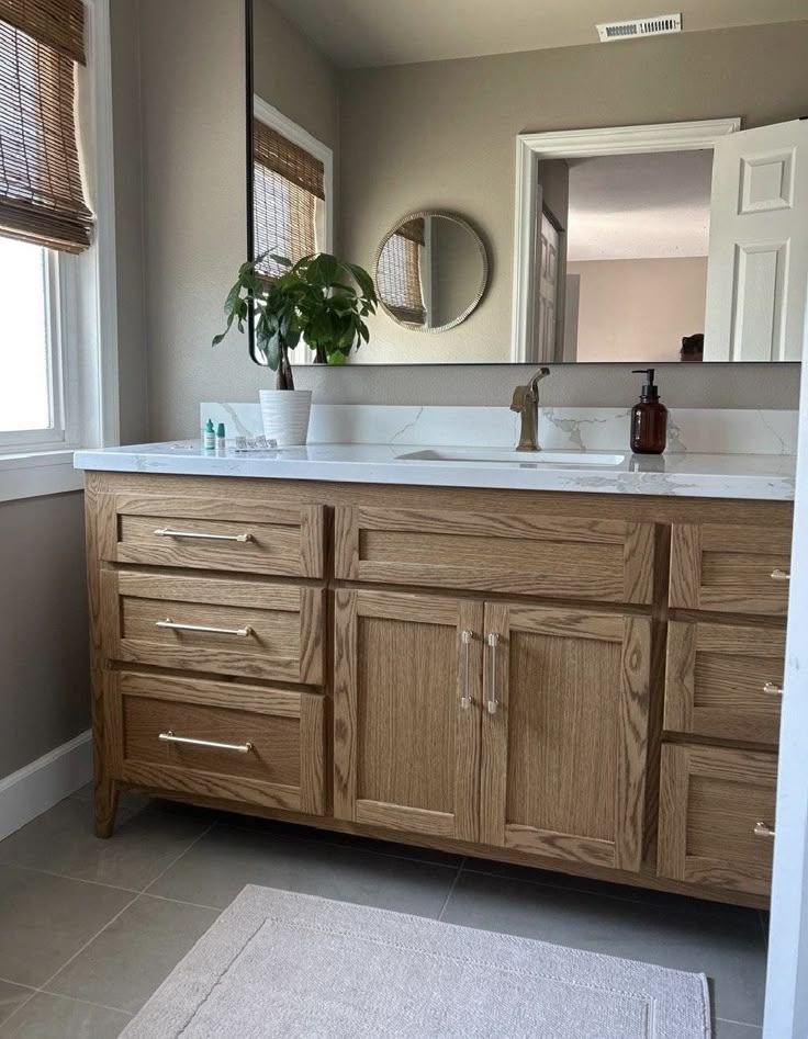 a bathroom vanity with two sinks and a large mirror