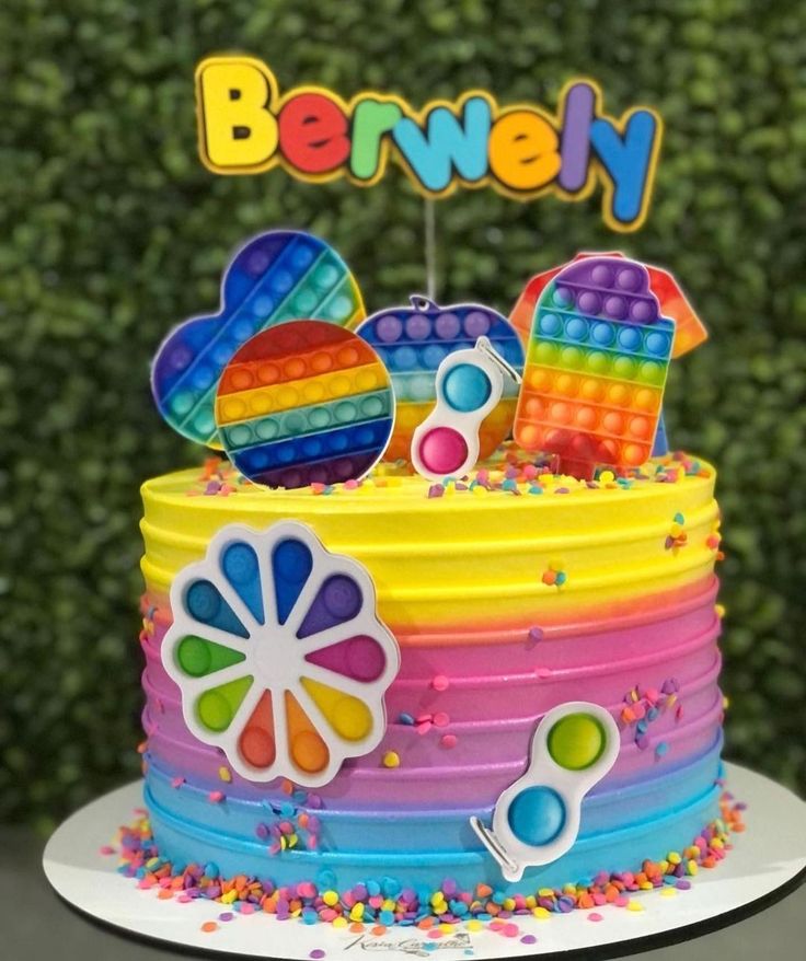 a colorful cake with the name berwely on it and an assortment of candies