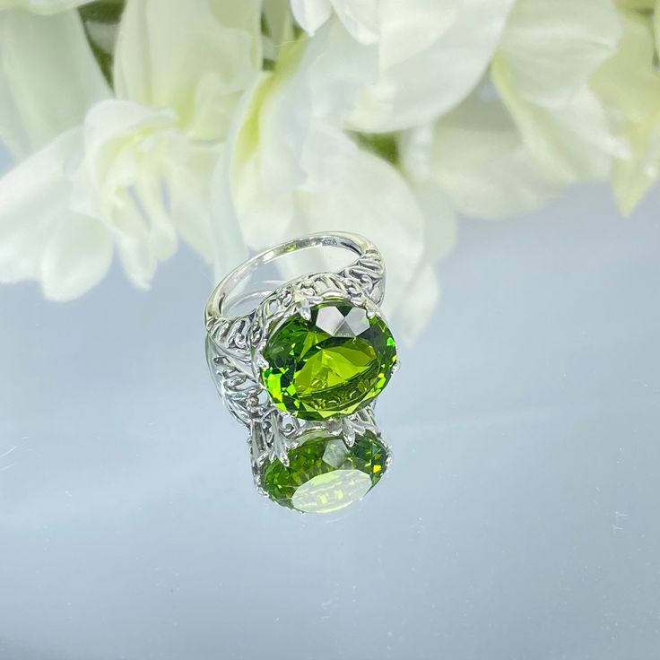 Peridot Sterling Silver RingKing Design#D123 This is a reproduction of a sterling silver Gothic filigree antique ring with a stunning 12 carat green peridot gemstone solitaire. This round cut simulated gem is 15mm in diameter. The inside of the band is marked 925 for sterling silver. Notice the beautiful intricate Gothic claw design of the silver filigree setting. The swirls echo down the band. This large round gemstone sits regally atop the fashionable setting. This stately ring garners attenti Elegant Green Sterling Silver Rings, Exquisite Green Ring With Center Stone, Formal Lime Green Rings With Center Stone, Green Cubic Zirconia Oval Rings, Exquisite Green Rings With Diamond Cut, Green Crystal Ring With Prong Setting For Formal Events, Exquisite Green Jewelry With Accent Stones, Elegant Green Crystal Ring With Accent Stones, Formal Green Sterling Silver Rings