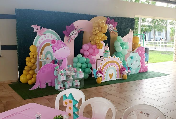 a birthday party setup with balloons, decorations and table cloths in the shape of unicorns