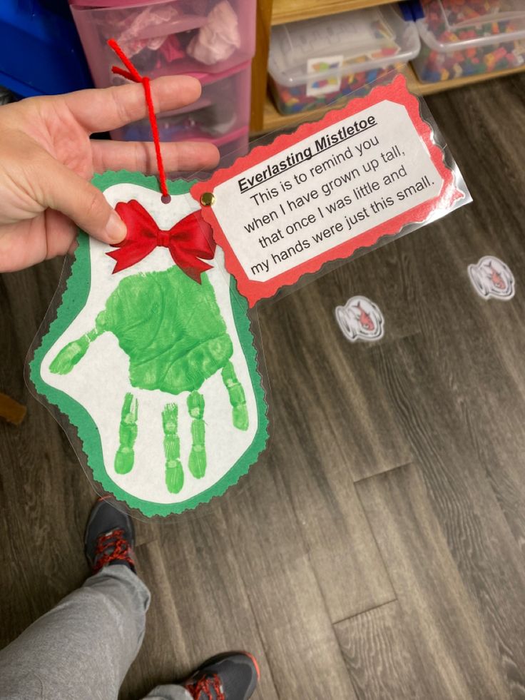 a person holding up a handprinted card with an elf's hand on it