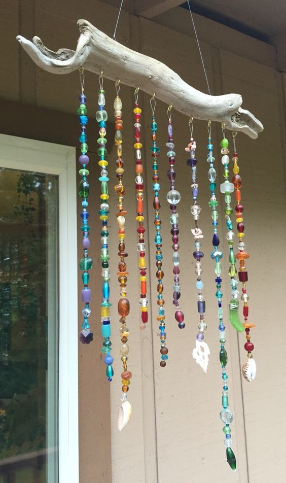 a wind chime hanging from the side of a building with lots of beads on it