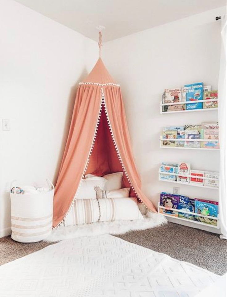 a child's bedroom with a teepee tent and bookshelf in the corner