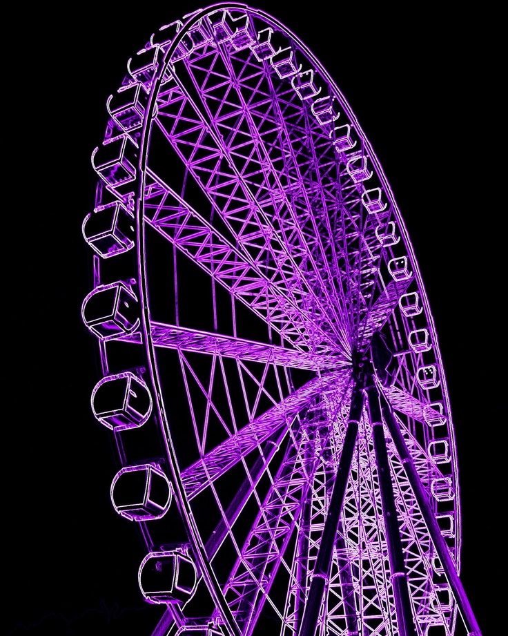 a purple ferris wheel lit up at night