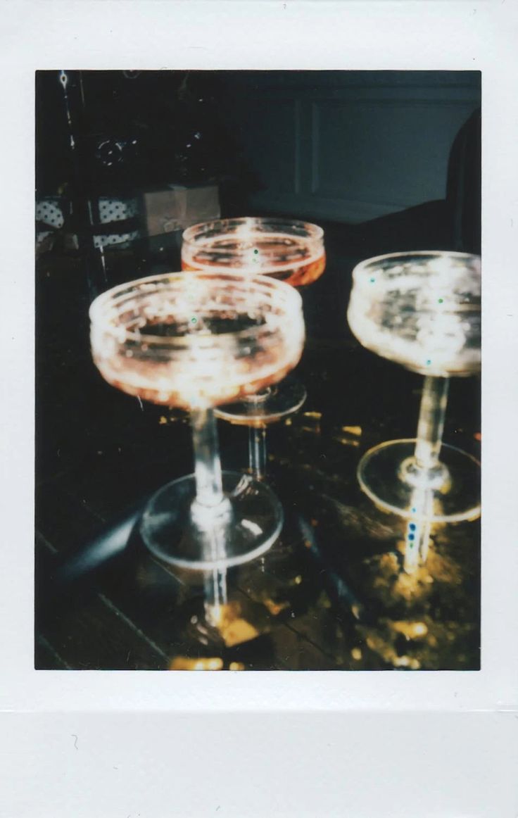 three wine glasses sitting on top of a table