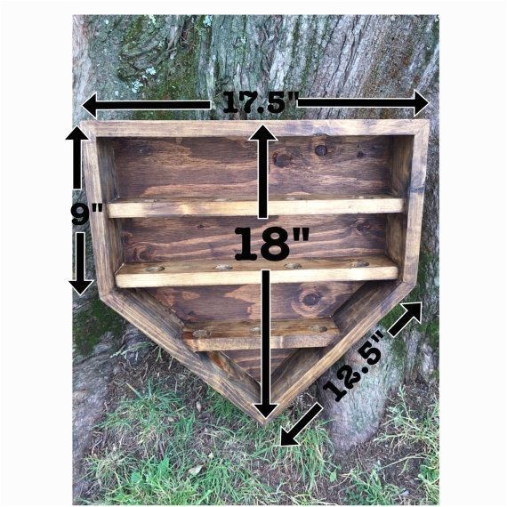 a wooden shelf sitting next to a tree with measurements for the top and bottom shelves