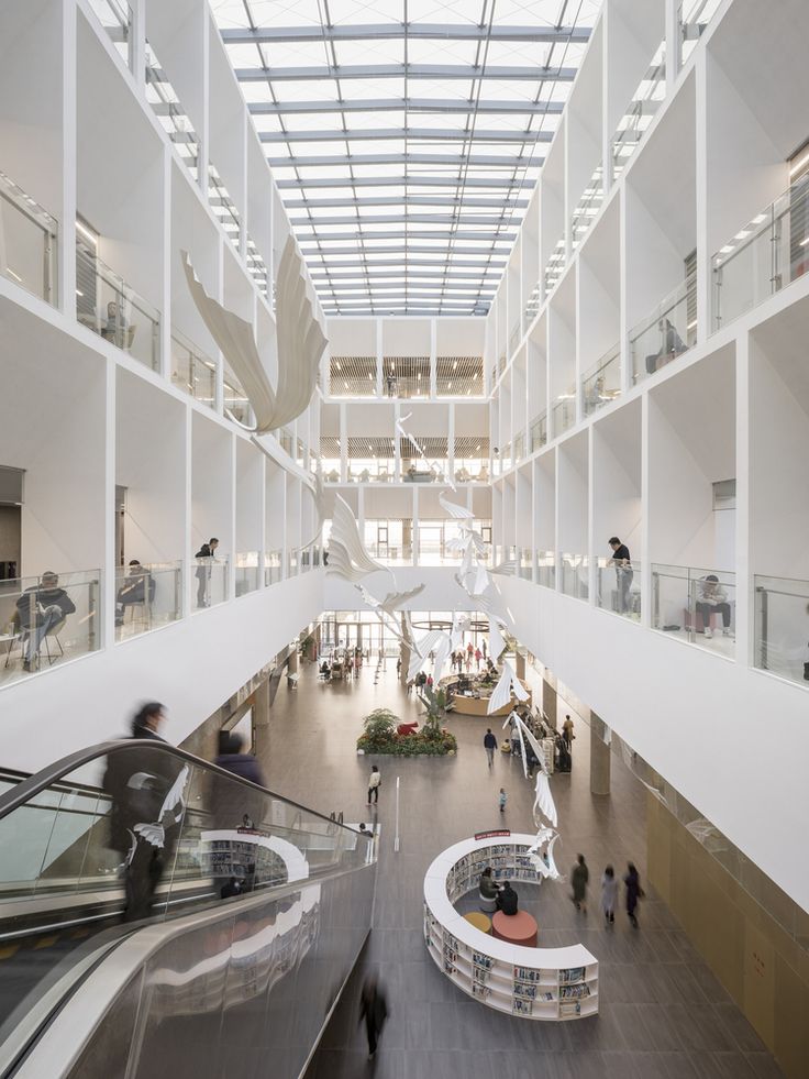 people are walking around in the atrium of a building