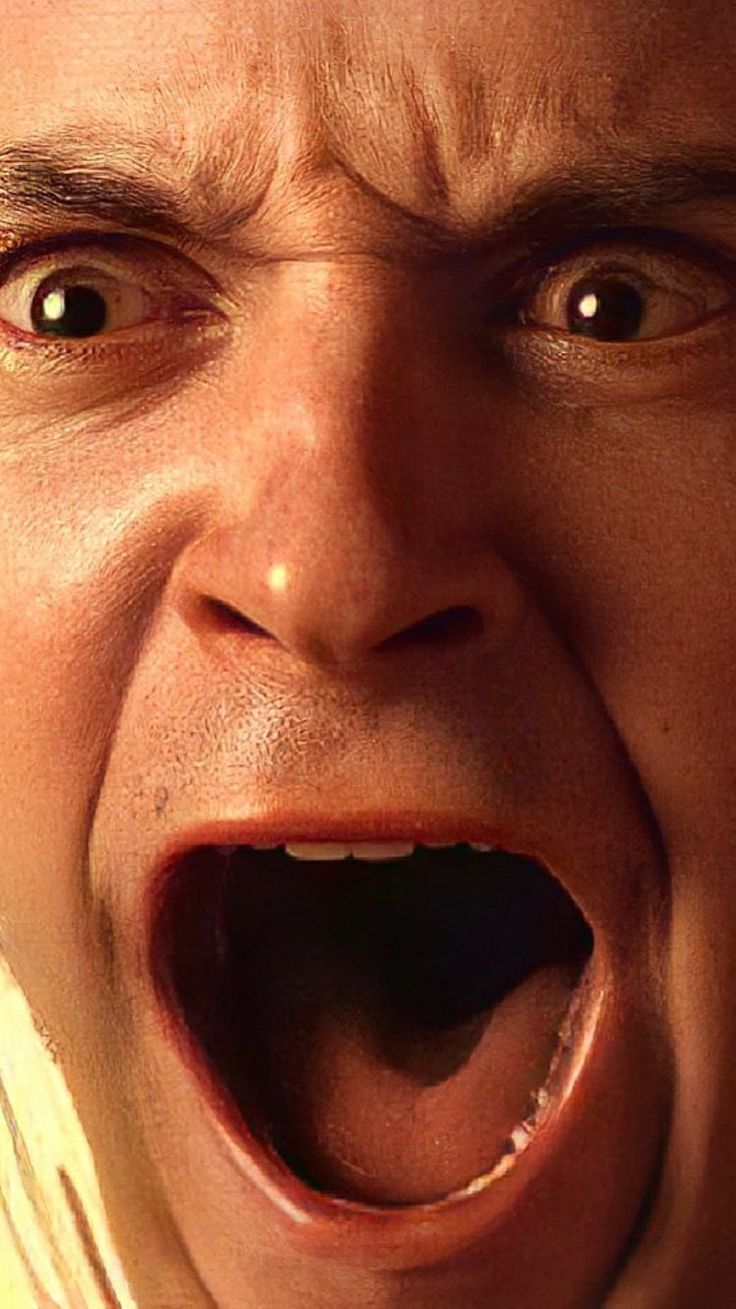 a close up of a person making a face with his mouth open and tongue out