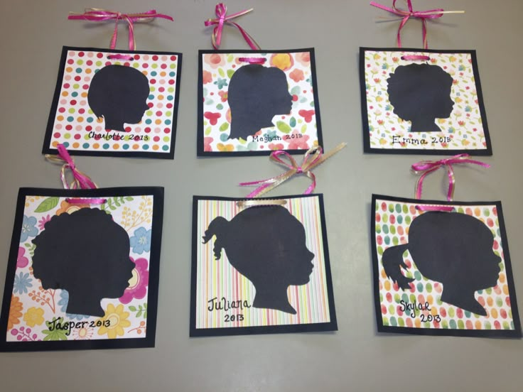 six silhouettes are hanging on the wall with pink bows and ribbons around them,