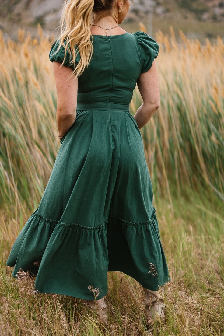 Welcome autumn in style with the Dahlia Dress in Green. This darling piece features a scoop neckline and short puff sleeves with elastic closures for a sweet and comfortable fit. The midi-length skirt with functional pockets and a ruffle tier hem adds just the right touch of seasonal charm to your wardrobe. Dahlia Dress, Welcome Autumn, White Bridal Dresses, Green Ivy, City Woman, White Dress Party, Bridesmaids And Groomsmen, Girls Dresses Summer, Midi Length Skirts