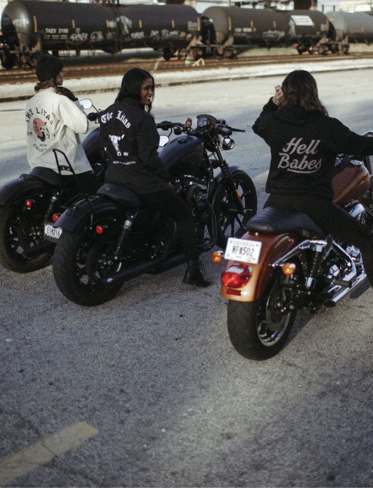 three people sitting on motorcycles in the street