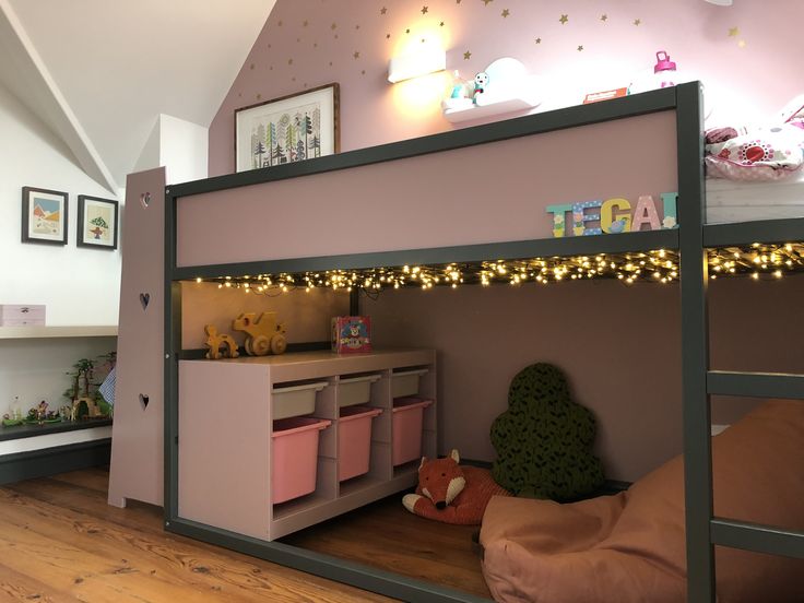 there is a bunk bed with pink drawers and lights on the wall above it in this room