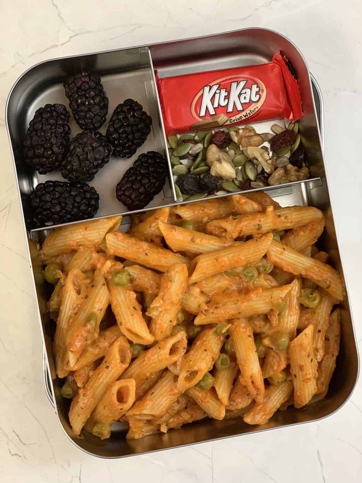 a metal container filled with pasta and blackberries