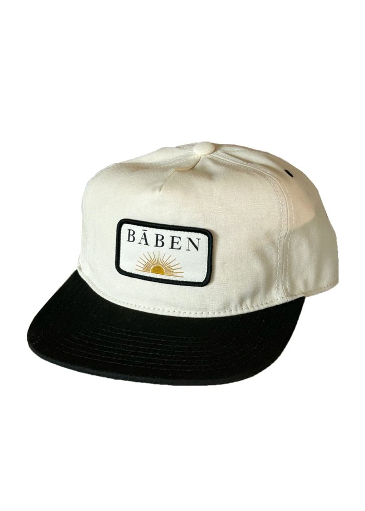 The BĀBEN cap is easy to wear for days spent in the sun. The hat is a mid-profile unstructured 5 panel cap cut in cotton canvas. It features an adjustable fit with a metal slider closure and a woven patch logo. Keeping it neutral with a two-tone creme and black colorway, it is versatile and perfect for salty hair days. Vintage pin not included. Fabric & Care Instructions: 100% Cotton Canvas Curved Brim Hats With Logo Patch For Summer, Curved Brim Summer Hats With Logo Patch, Summer Hats With Logo Patch And Curved Brim, Adjustable Canvas Hat With Logo Patch, Urban Snapback Hat Adjustable For Everyday, Summer Cotton Trucker Hat With Logo Patch, White Summer Hats With Logo Patch, Urban Style Flat Brim Snapback Hat For Summer, Urban Style Snapback Hat With Flat Brim For Summer