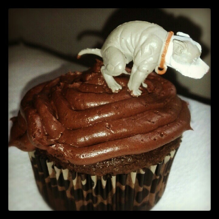 a cupcake with chocolate frosting and an elephant figurine on top