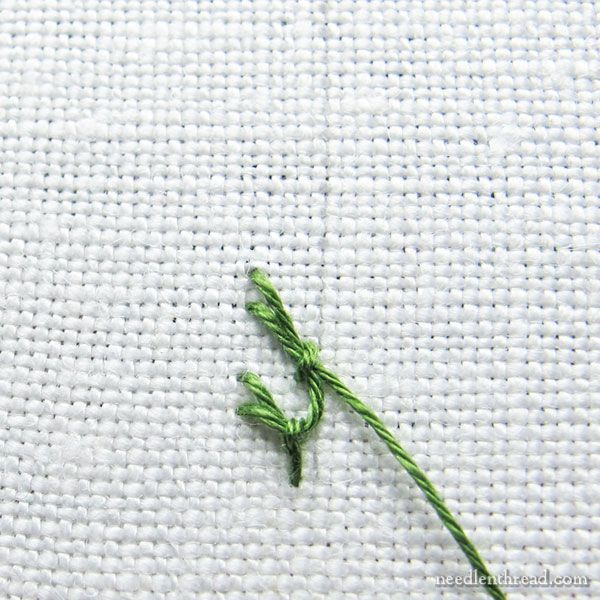 the green thread has been stitched onto the white fabric