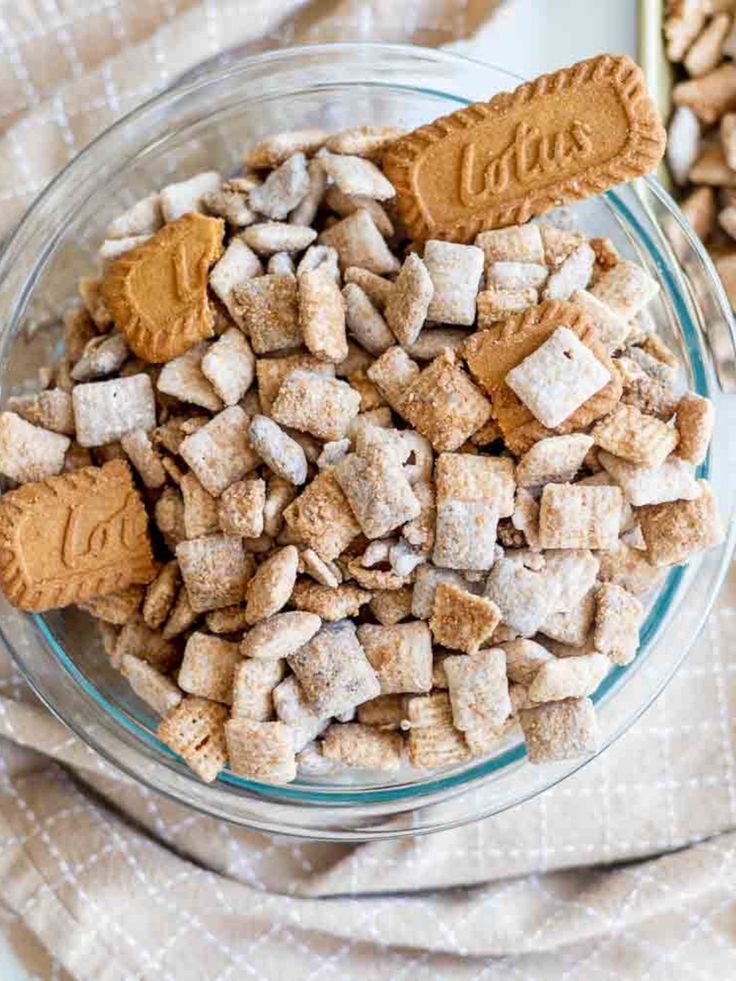 a glass bowl filled with marshmallows on top of a table next to a spoon