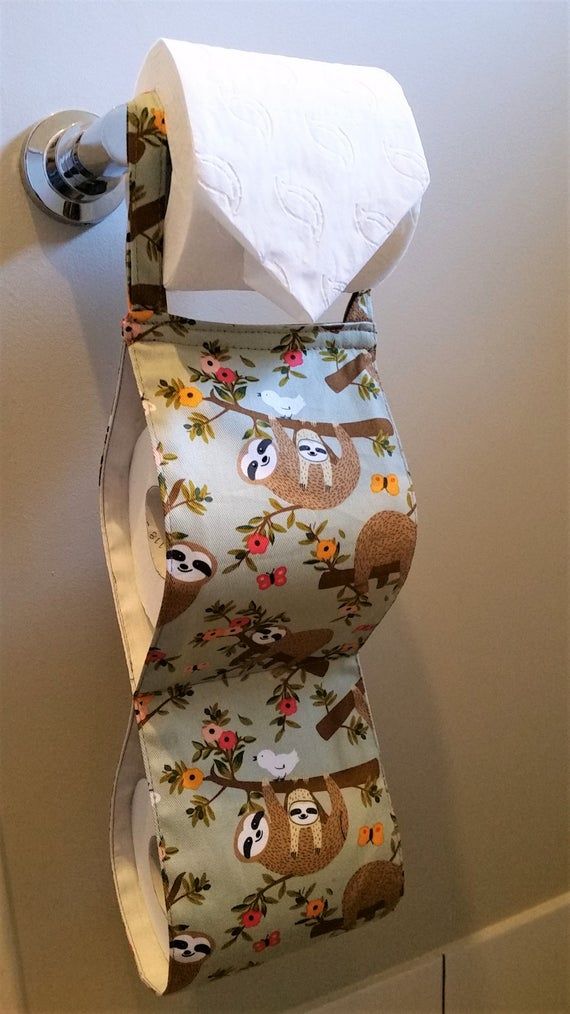 a roll of toilet paper hanging from a wall with slots and flowers on it