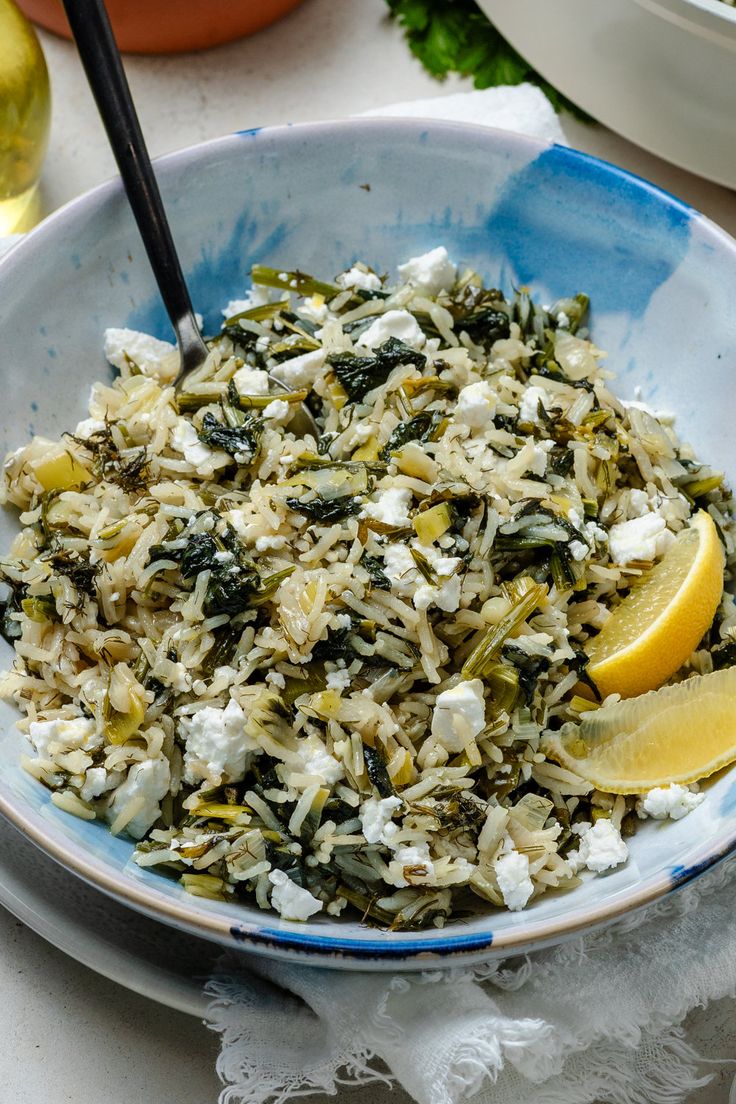 a blue bowl filled with rice and lemon wedges