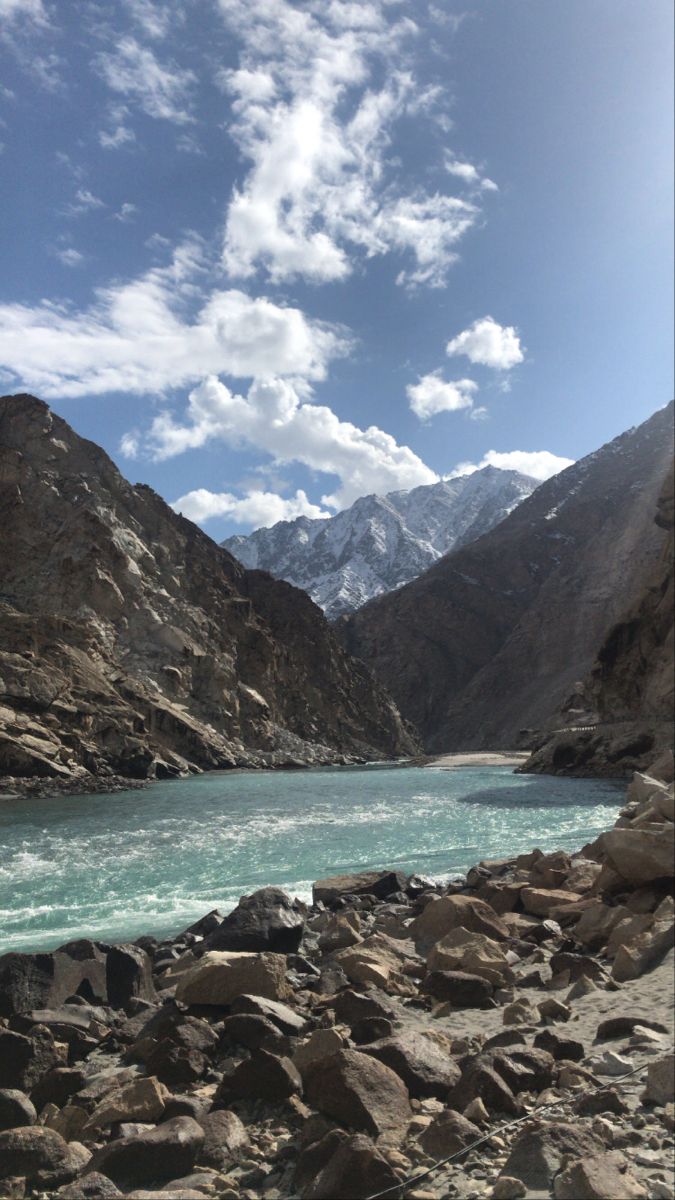 there is a mountain lake in the middle of rocks and boulders on the side of the river