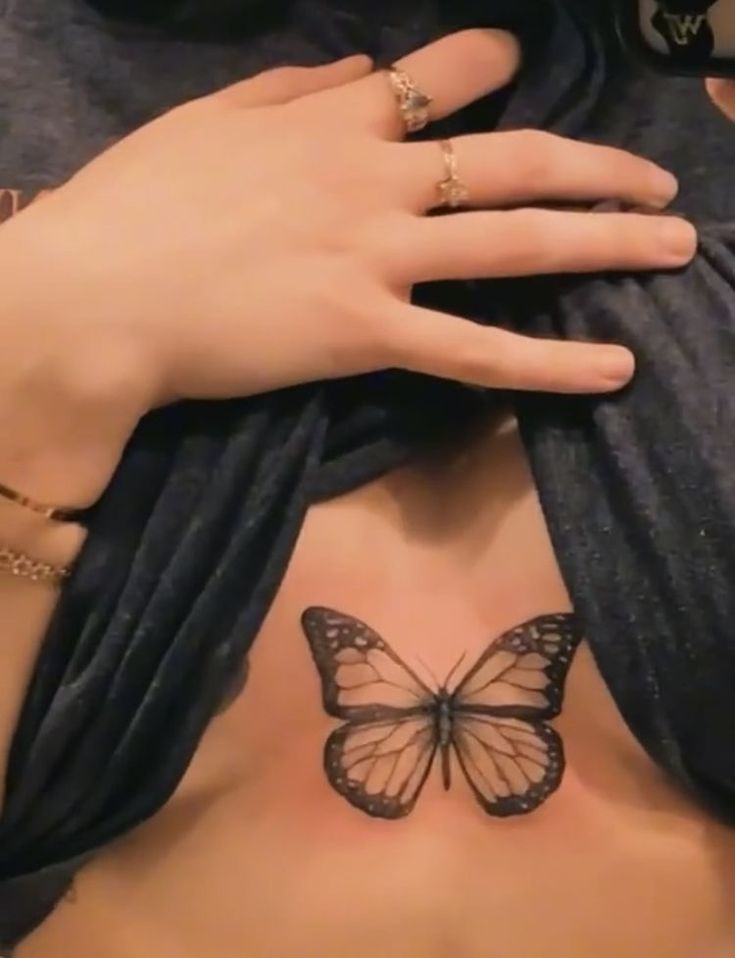 a woman's chest with a butterfly tattoo on her left side and right breast