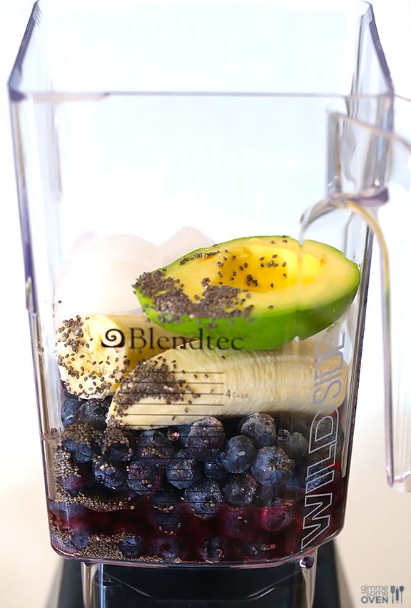 a blender filled with blueberries, bananas and kiwi on top of a counter