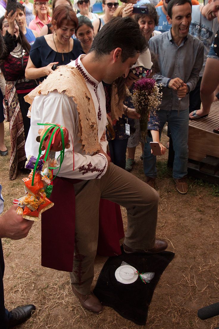 a man sitting on top of a stool in front of a group of other people